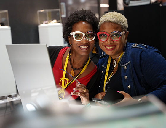 Two women smiling with glasses