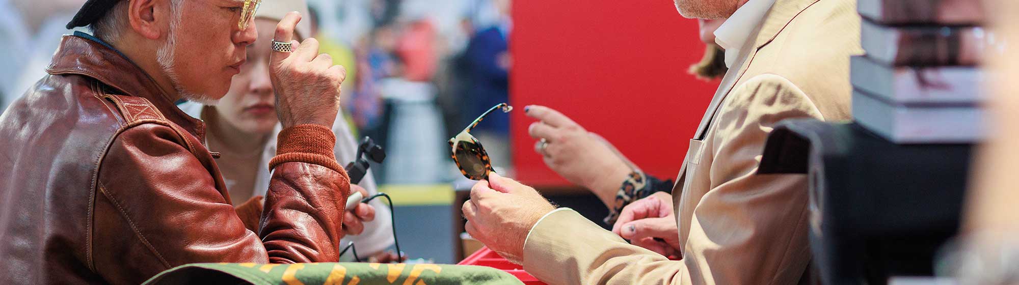 Un exposant montrant une paire de lunettes à un visiteur