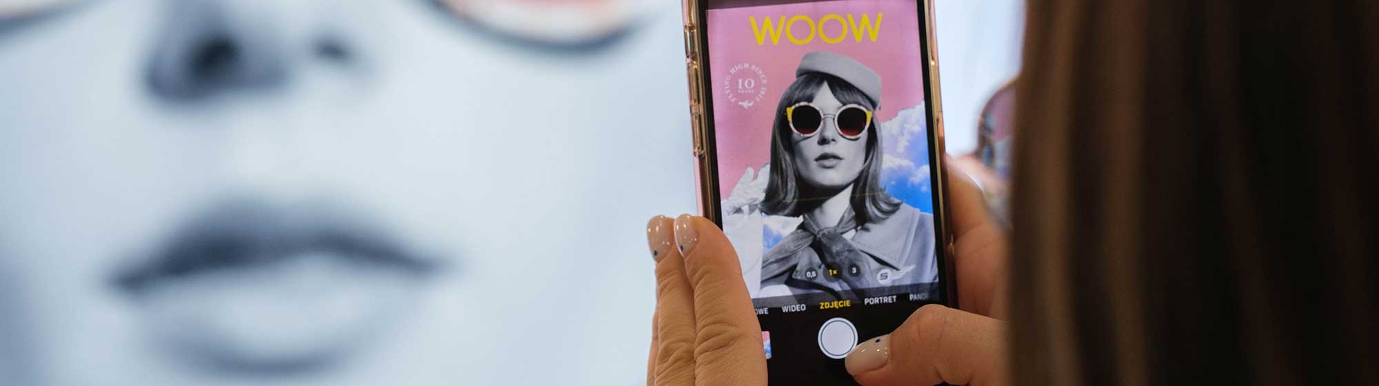 Femme photographiant un panneau avec son téléphone