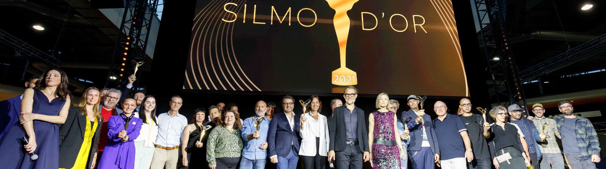 Men and women, winners of the SILMO d'Or 2021, raising their trophies