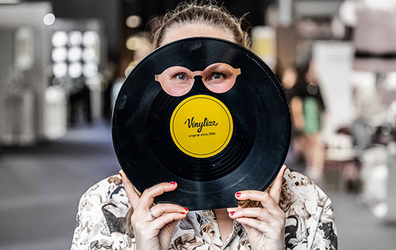 Femme tenant un vinyle découpé en forme de lunettes
