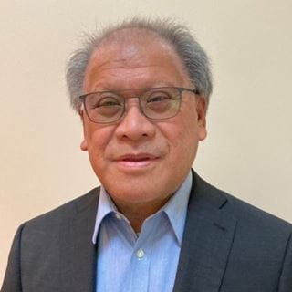 Portrait of an Asian man in a dark suit, nominee for the International Optician of the Year Award 2025