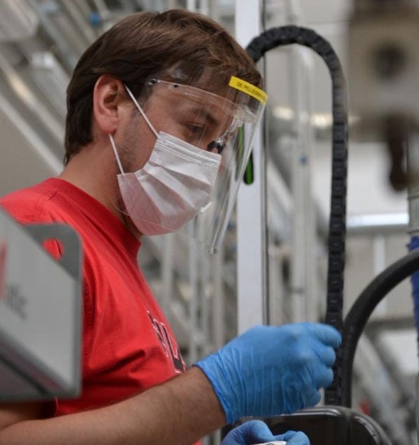 Homme avec un masque travaillant sur des matériaux Bioline