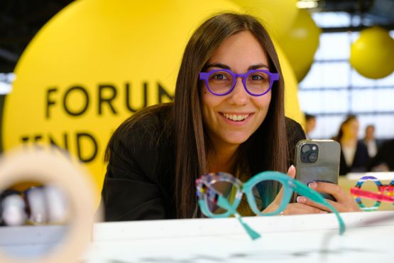 Woman with purple glasses taking pictures of new products at the Trends Forum 2024 of SILMO Paris