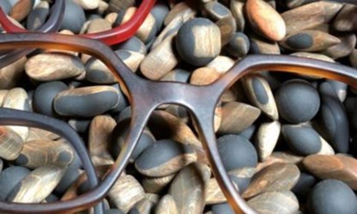 Gros plan sur des montures de lunettes élégantes posées sur des galets