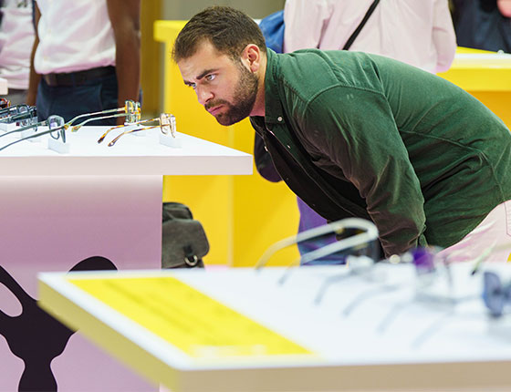Homme observant des lunettes posées sur une table